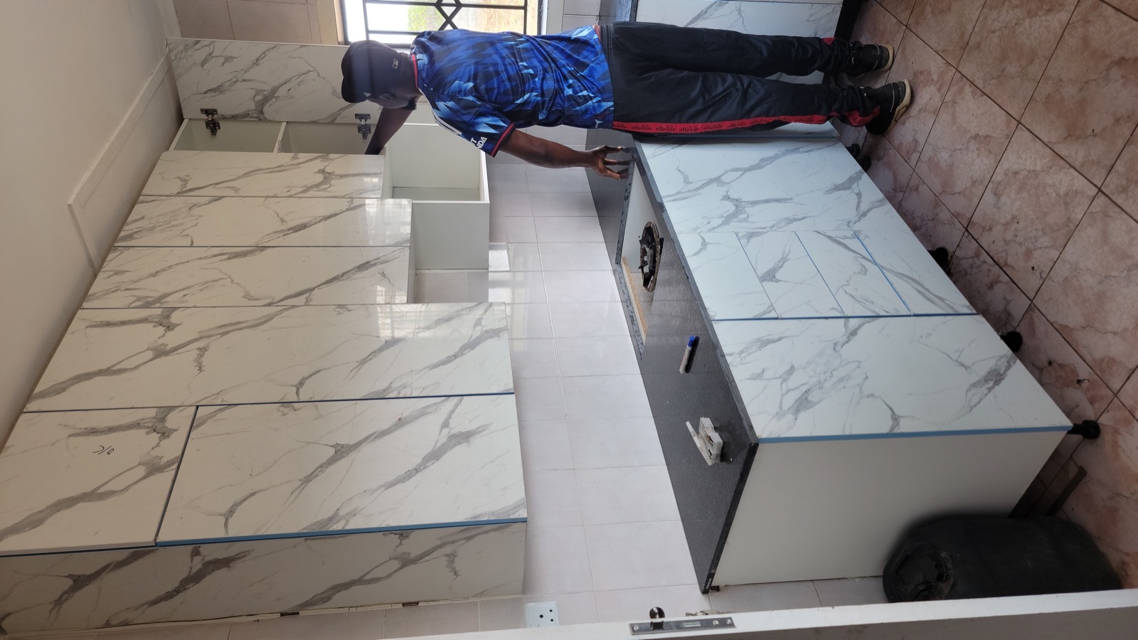 Installer checking an upper cabinet during kitchen fitting