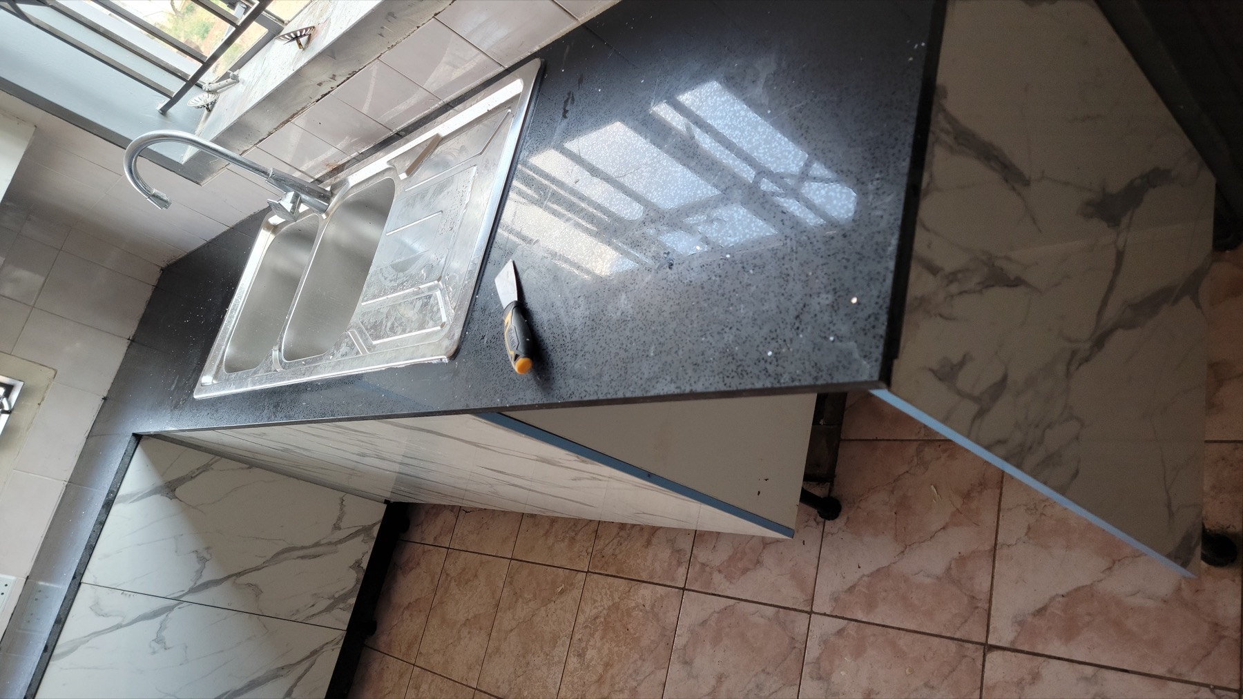 Polished black countertop and double sink installed by It Works