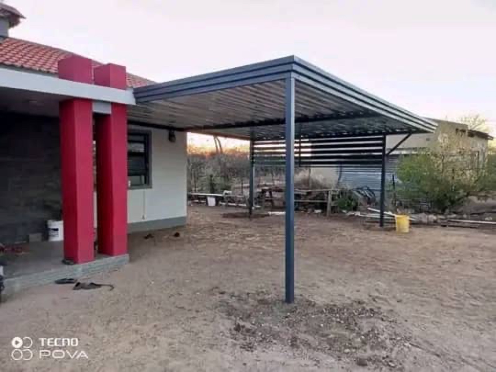 Finished charcoal carport structure outside a home