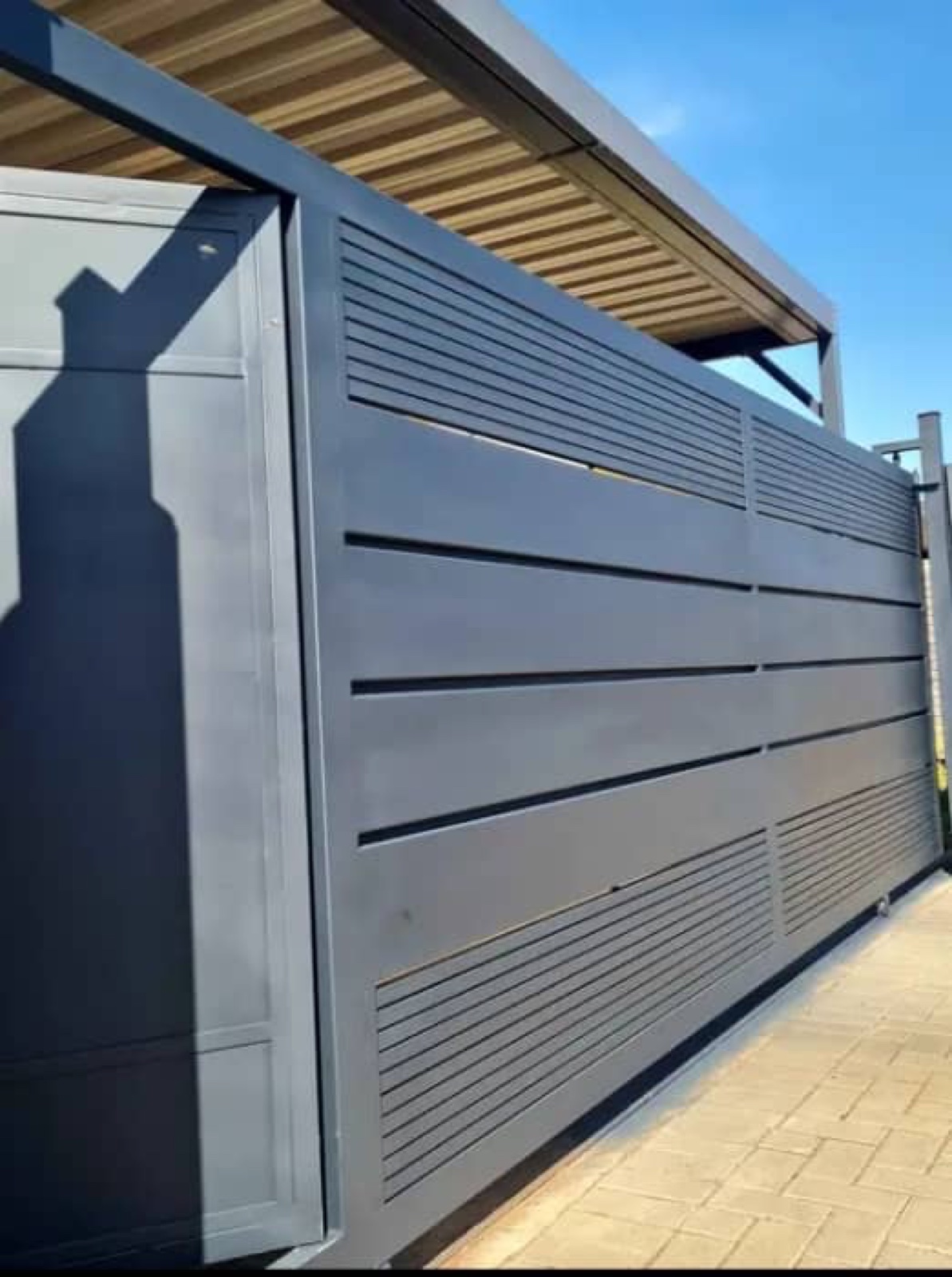 Charcoal sliding security gate installed at a driveway